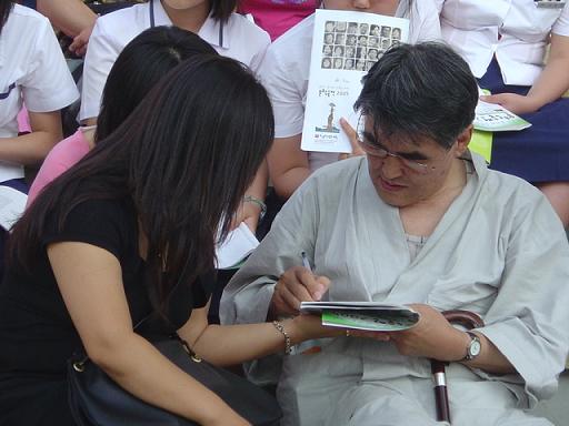 문학 행사장에서 독자에게 사인을 해주고 있는 김지하 시인. 